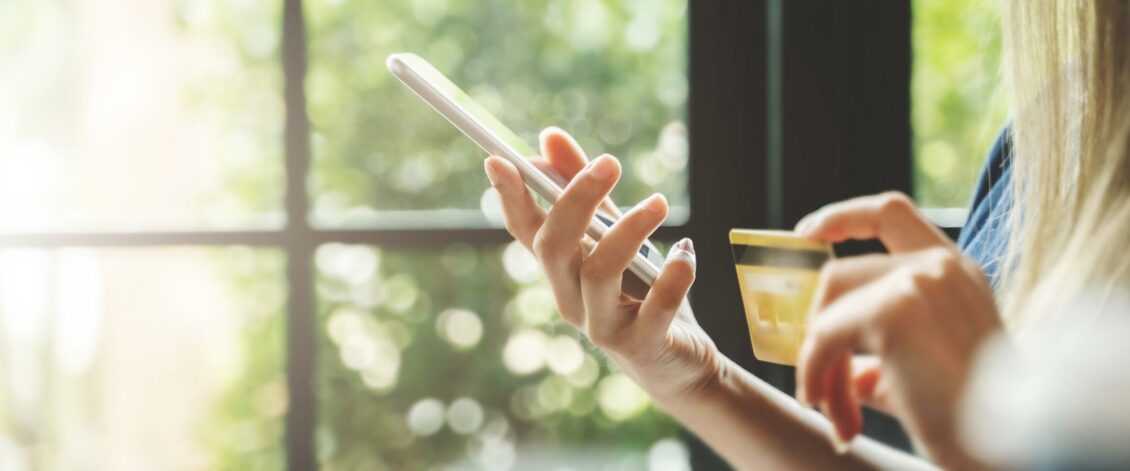 person buying something on their cell phone using a credit card