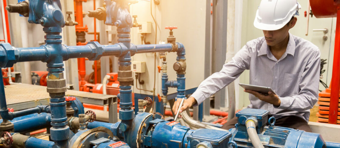 Man checking data on a tablet whilst in a manufacturing plant