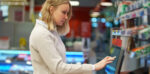 Woman using a self checkout in a store