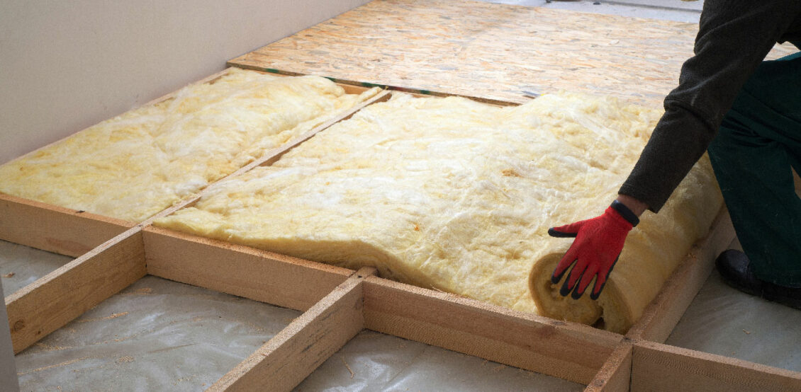 A person installing loft insulation